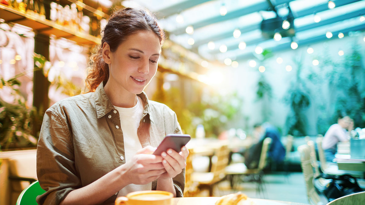 Person making a social post on their phone at a restaurant